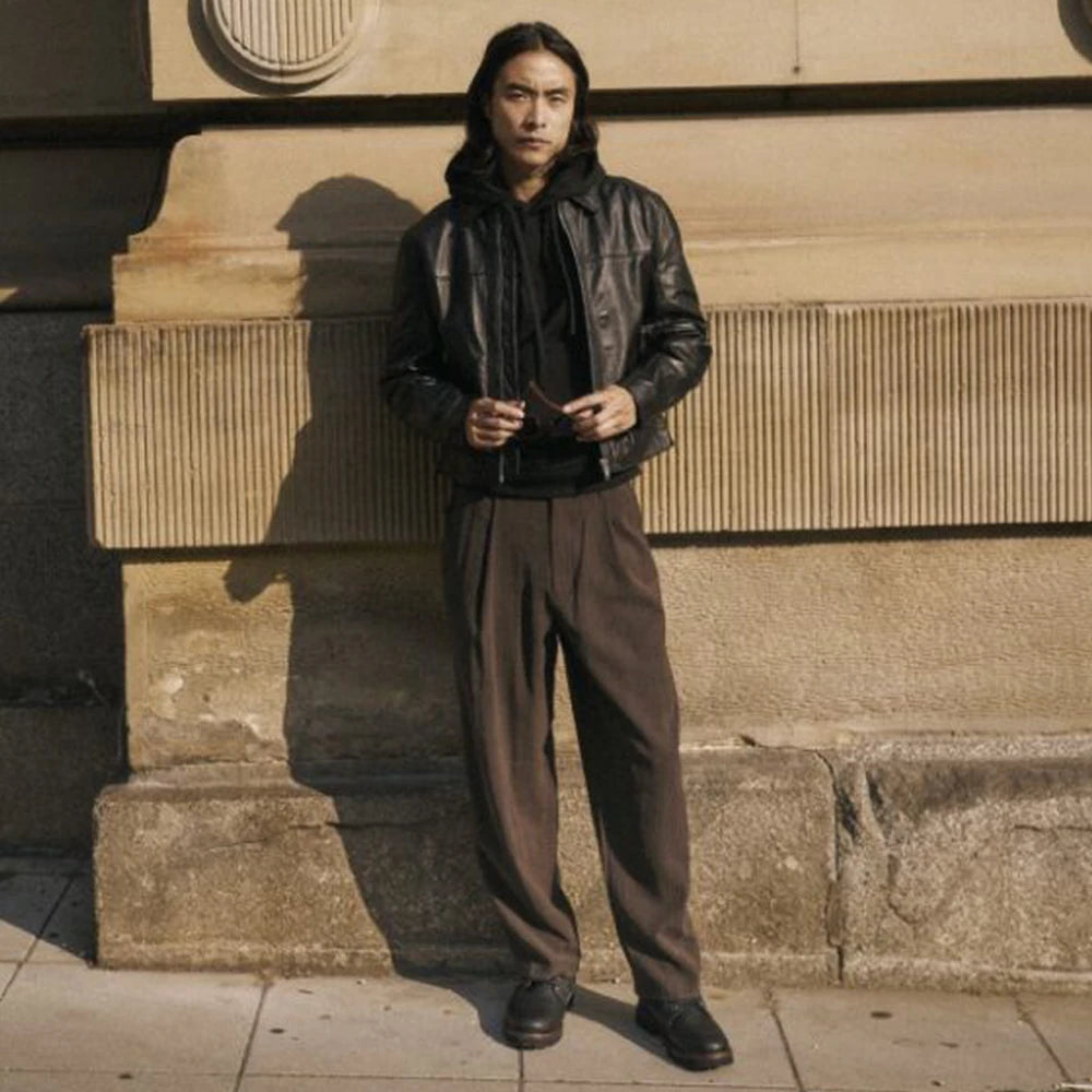man standing by a wall with sioux boots