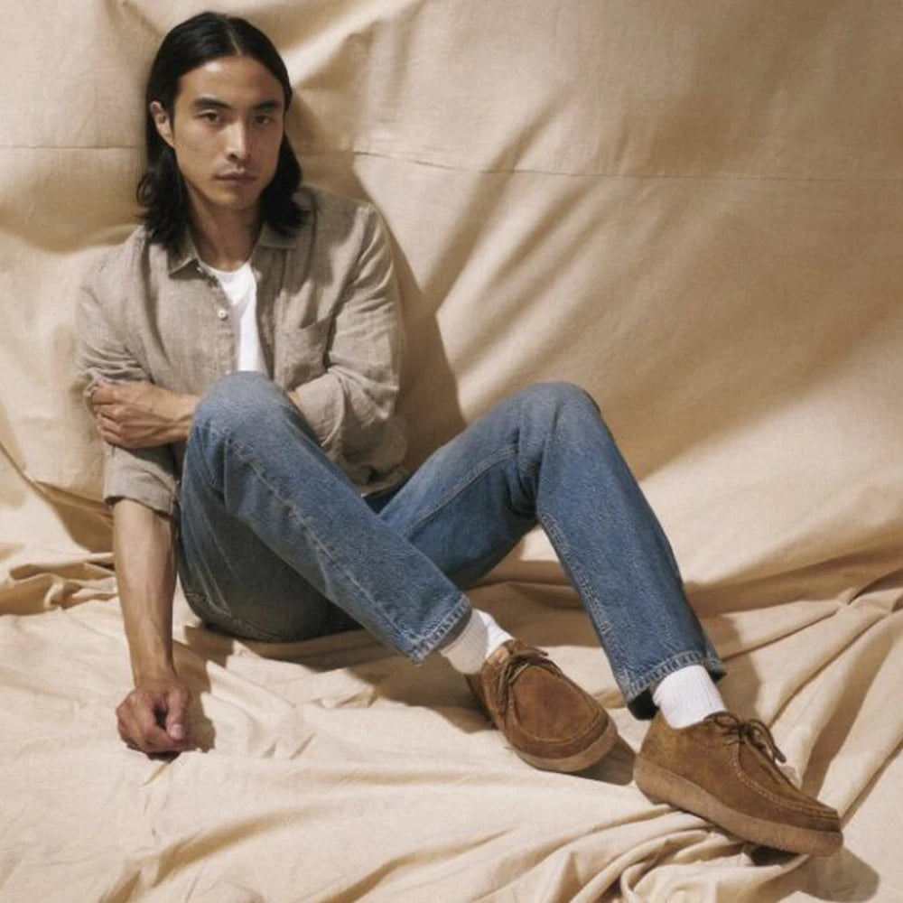 man sitting on the floor wearing brown suede sioux shoes
